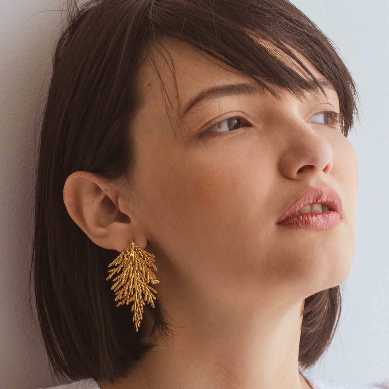 Aretes Hoja Pino Grande en bronce bañado en oro de 24k, destacando la belleza natural de las hojas de pino inmortalizadas