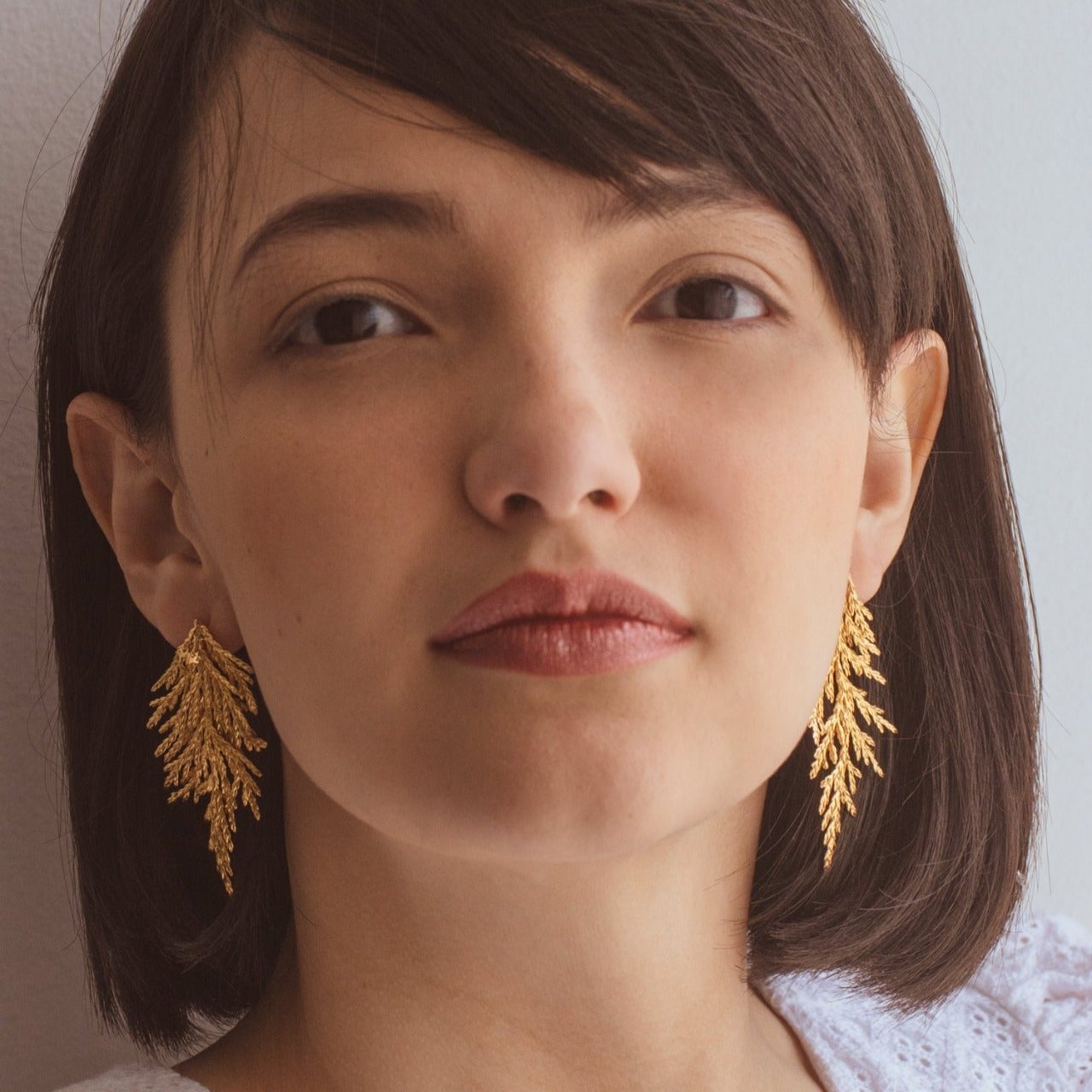 Aretes Hoja Pino Grande en bronce bañado en oro de 24k, destacando la belleza natural de las hojas de pino inmortalizadas