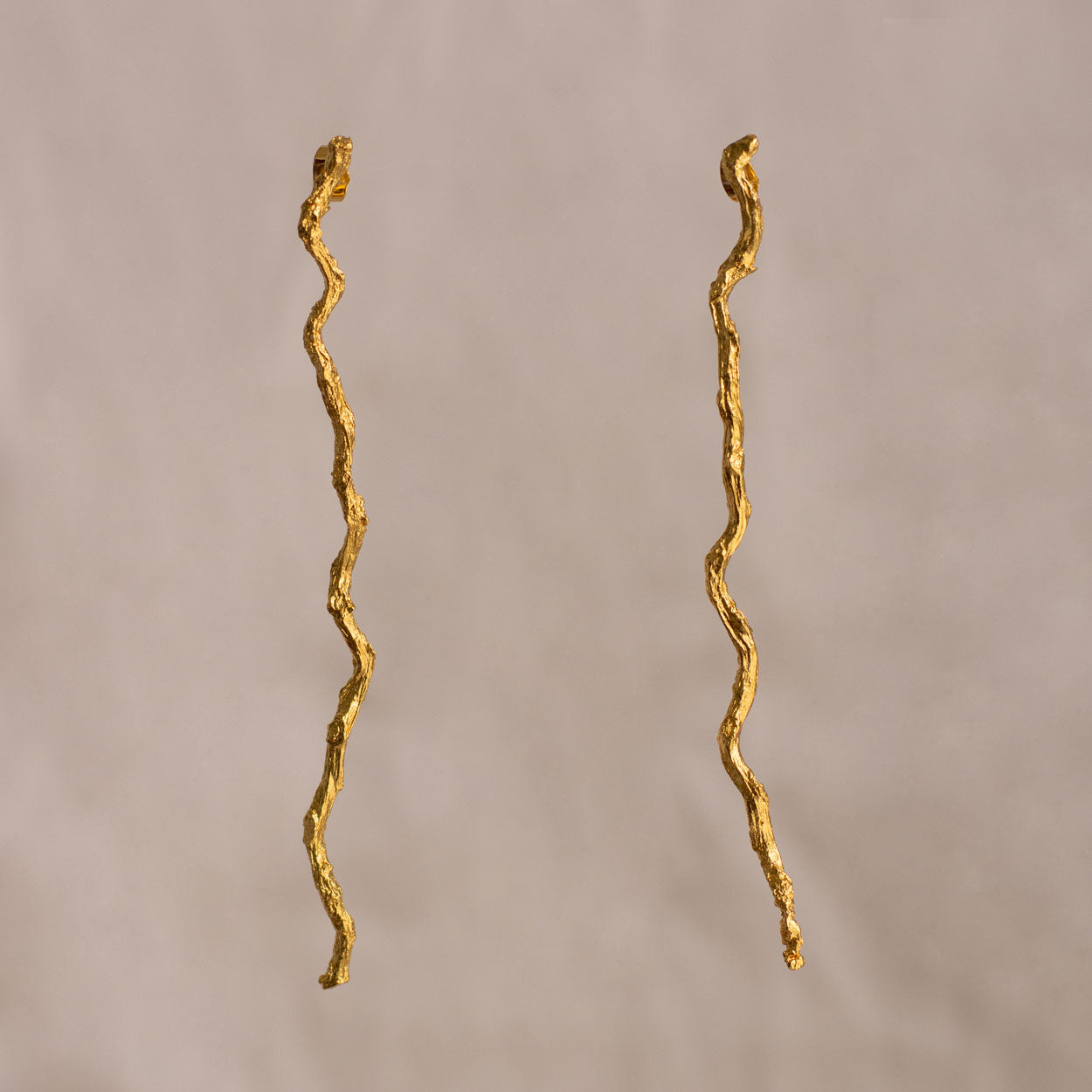 Aretes Large Ramita Palma Coco en bronce bañado en oro de 24k, con diseño natural