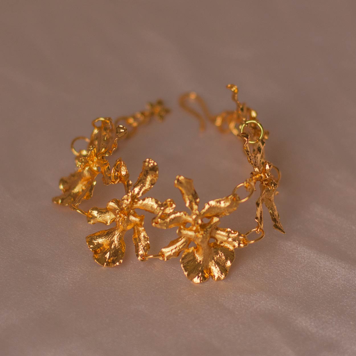 Pulsera Cinco Orquídeas Chocolate en bronce bañado en oro de 24k, destacando la belleza única de las orquídeas inmortalizadas.