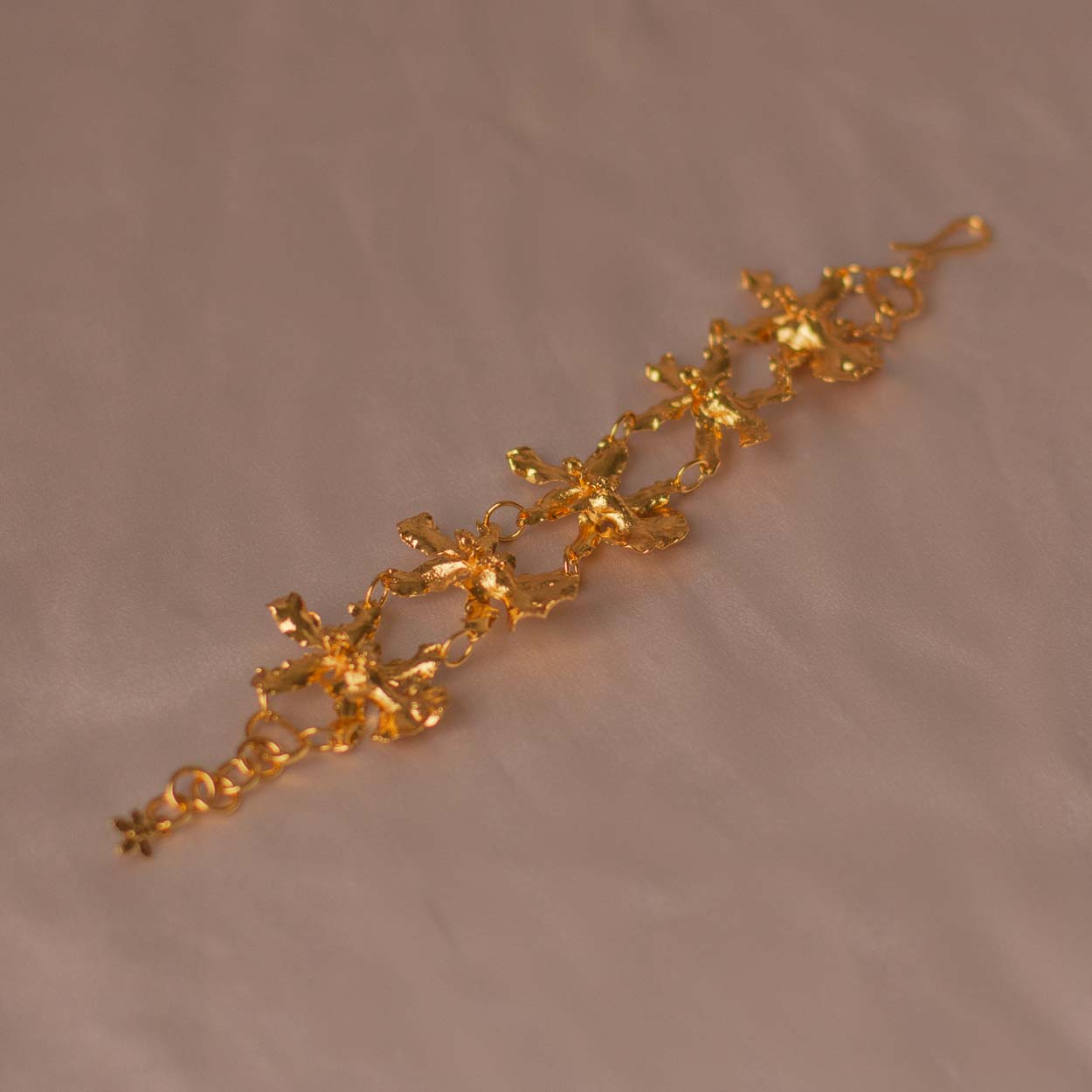 Pulsera Cinco Orquídeas Chocolate en bronce bañado en oro de 24k, destacando la belleza única de las orquídeas inmortalizadas.