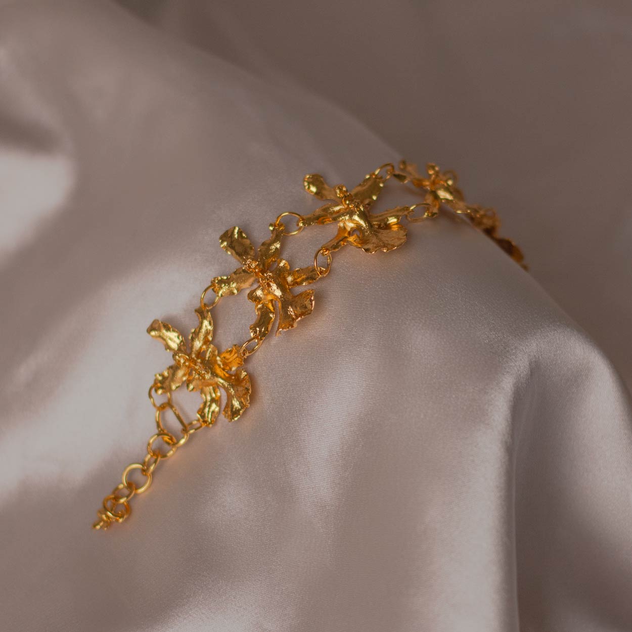 Pulsera Cinco Orquídeas Chocolate en bronce bañado en oro de 24k, destacando la belleza única de las orquídeas inmortalizadas.