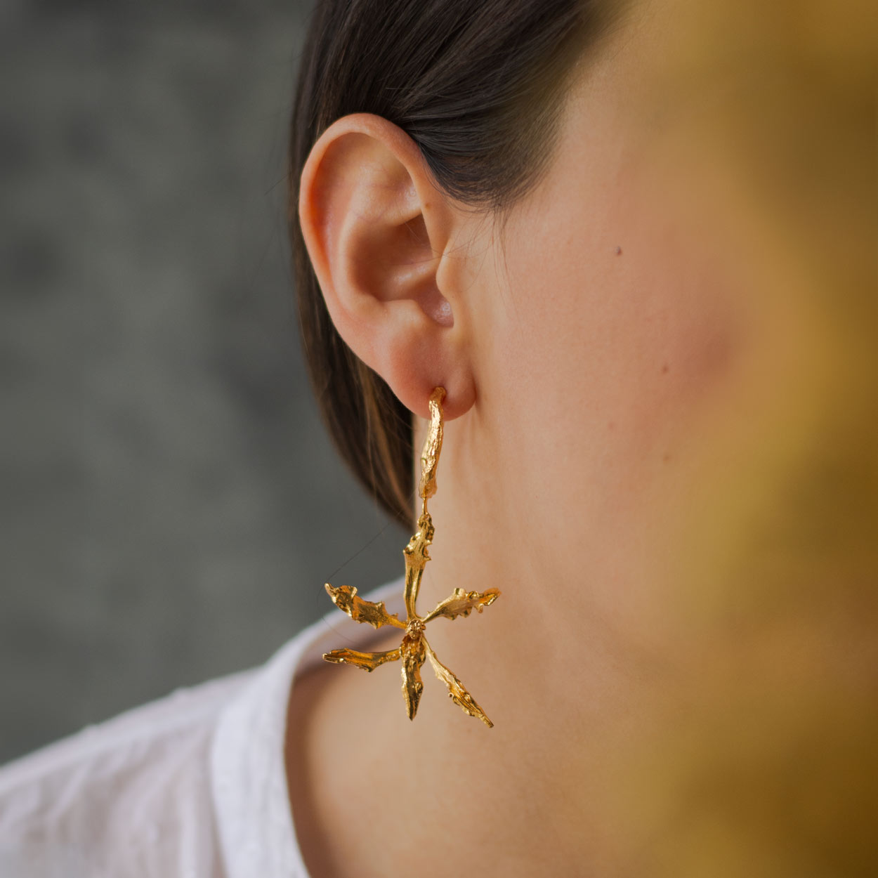 Aretes Candonga Orquídea Cyrtochilum Revolutum en bronce bañado en oro de 24k, destacando la belleza única de las orquídeas andinas inmortalizadas.