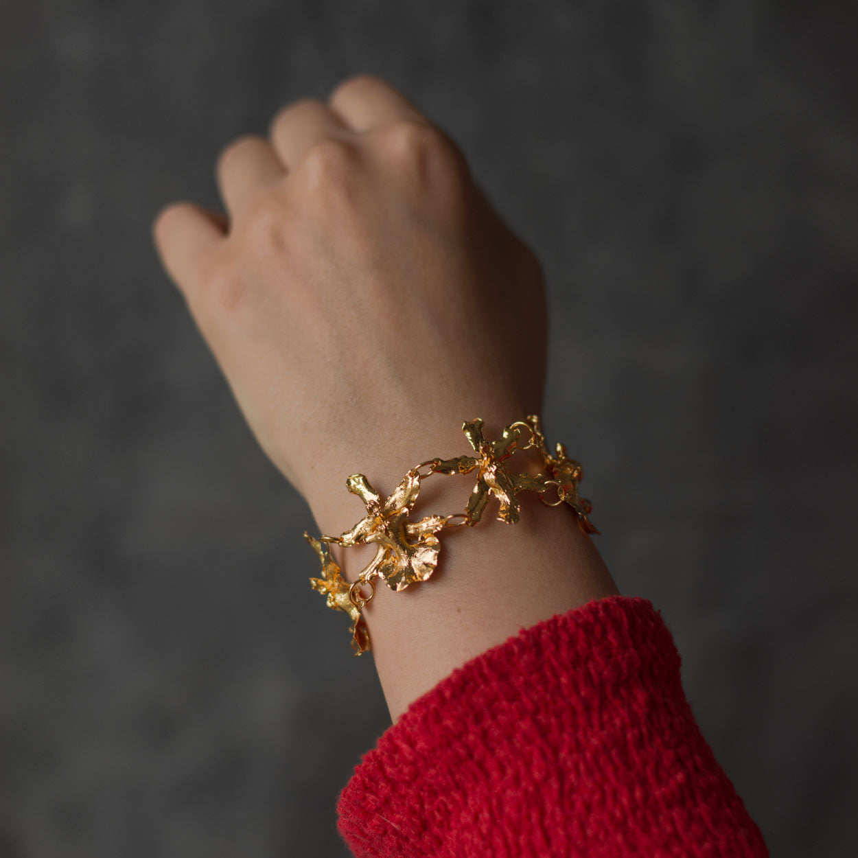 Pulsera Cinco Orquídeas Chocolate en bronce bañado en oro de 24k, destacando la belleza única de las orquídeas inmortalizadas.