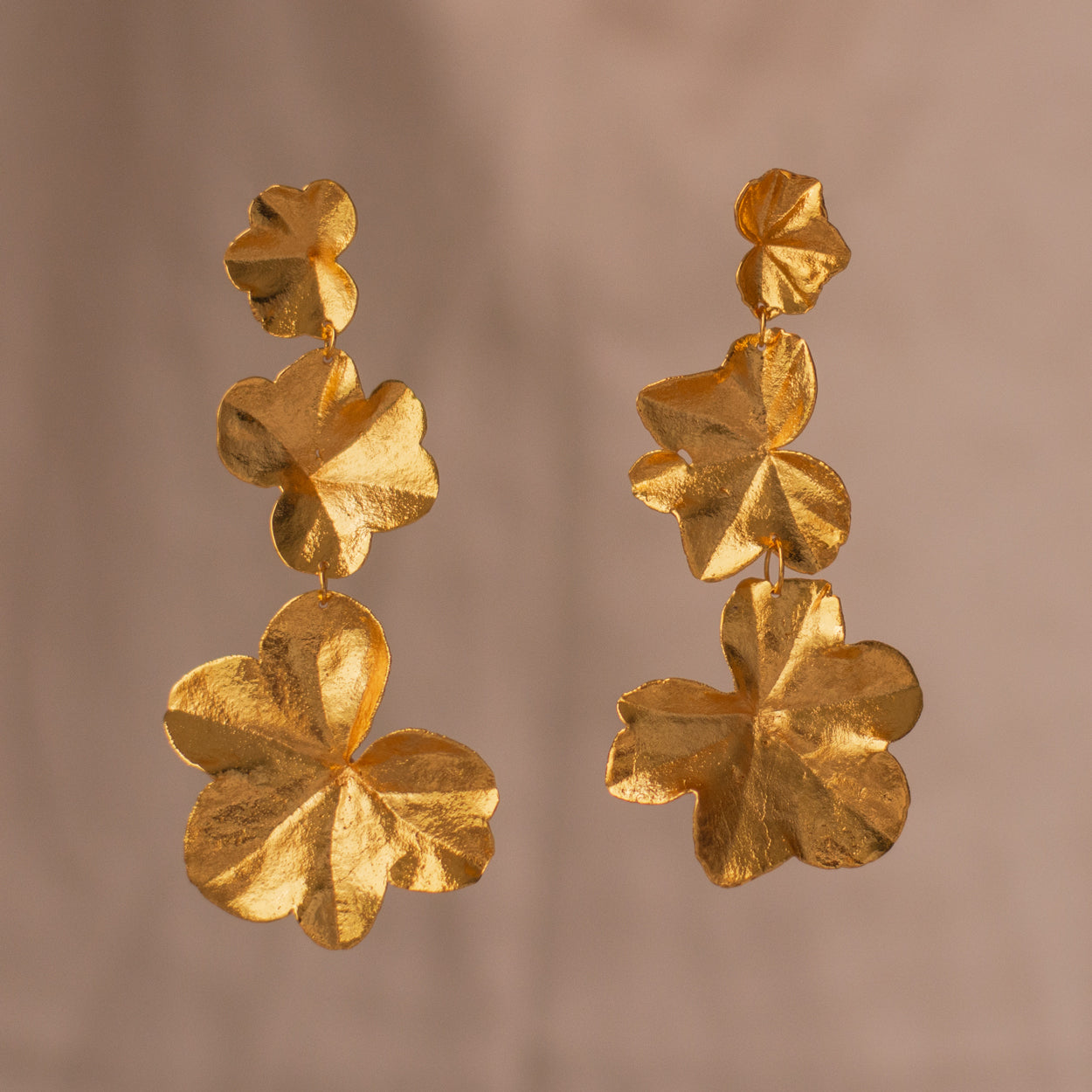 Aretes Largos Tres Hojas Hiedra en bronce bañado en oro de 24k, destacando la forma natural y única de las hojas inmortalizadas.