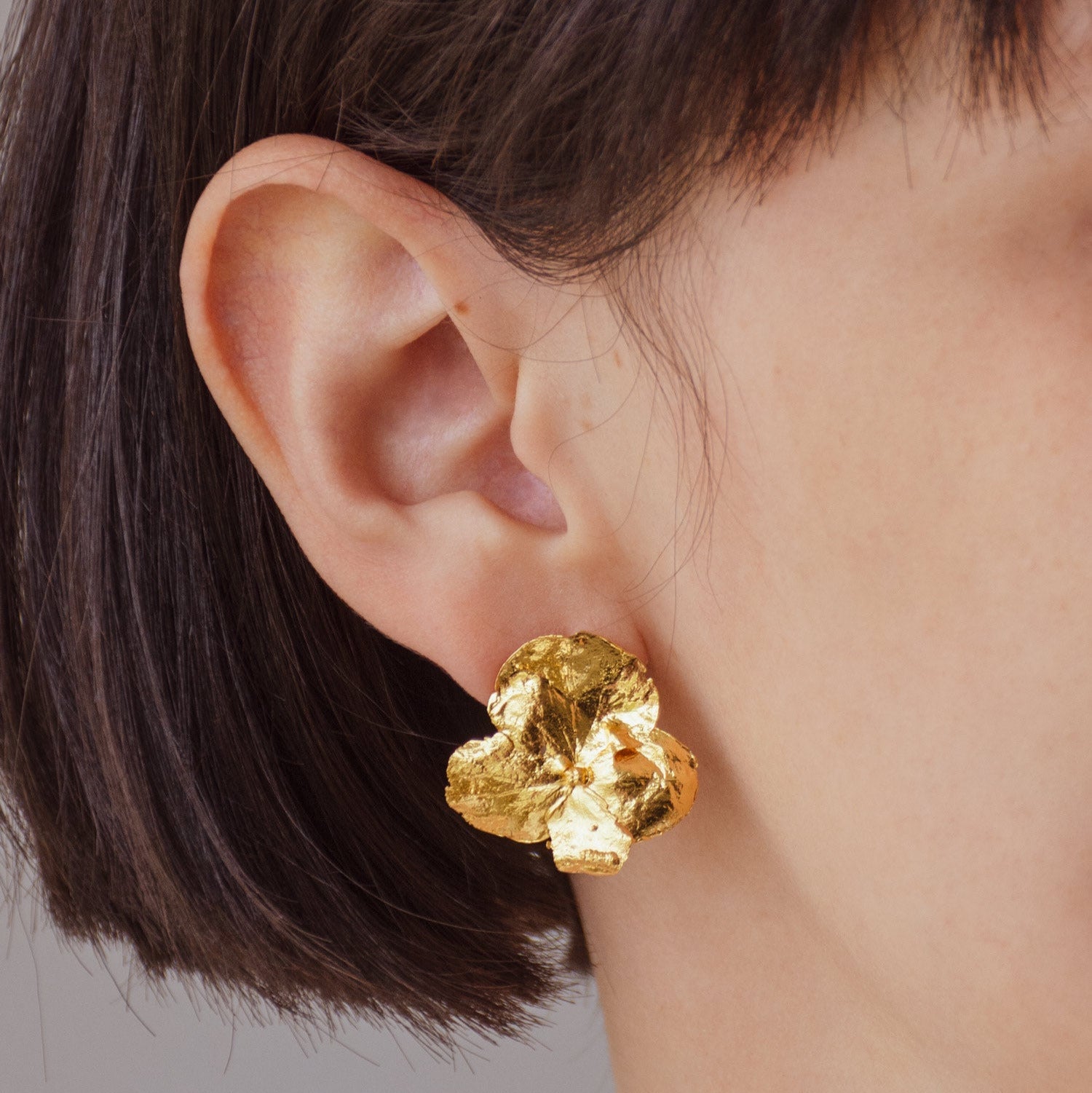Aretes Topo Flor Hortensia en bronce bañado en oro de 24k, destacando la belleza única de las flores naturales de hortensia de nuestro jardín