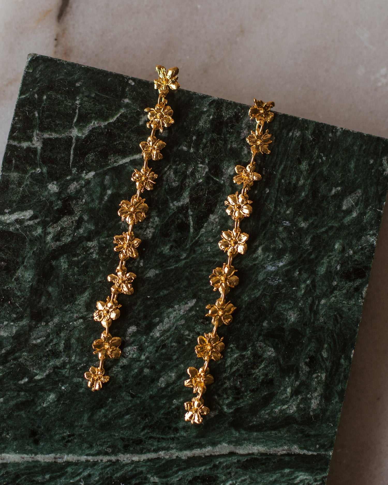 Aretes Large Sauco en bronce bañado en oro de 24k, con diez flores de sauco inmortalizadas en un diseño largo y articulado