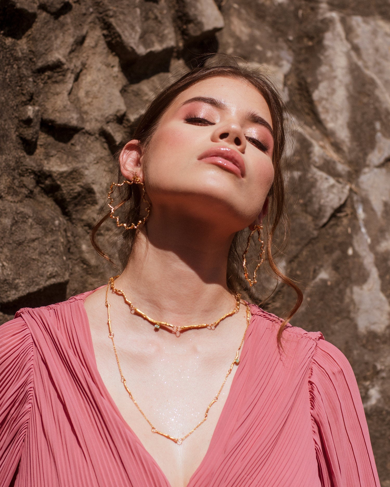 Mujer usando joyas statement de moda diseño de ramas naturales inmortalizadas en bronce con baño en oro de 24 kilates