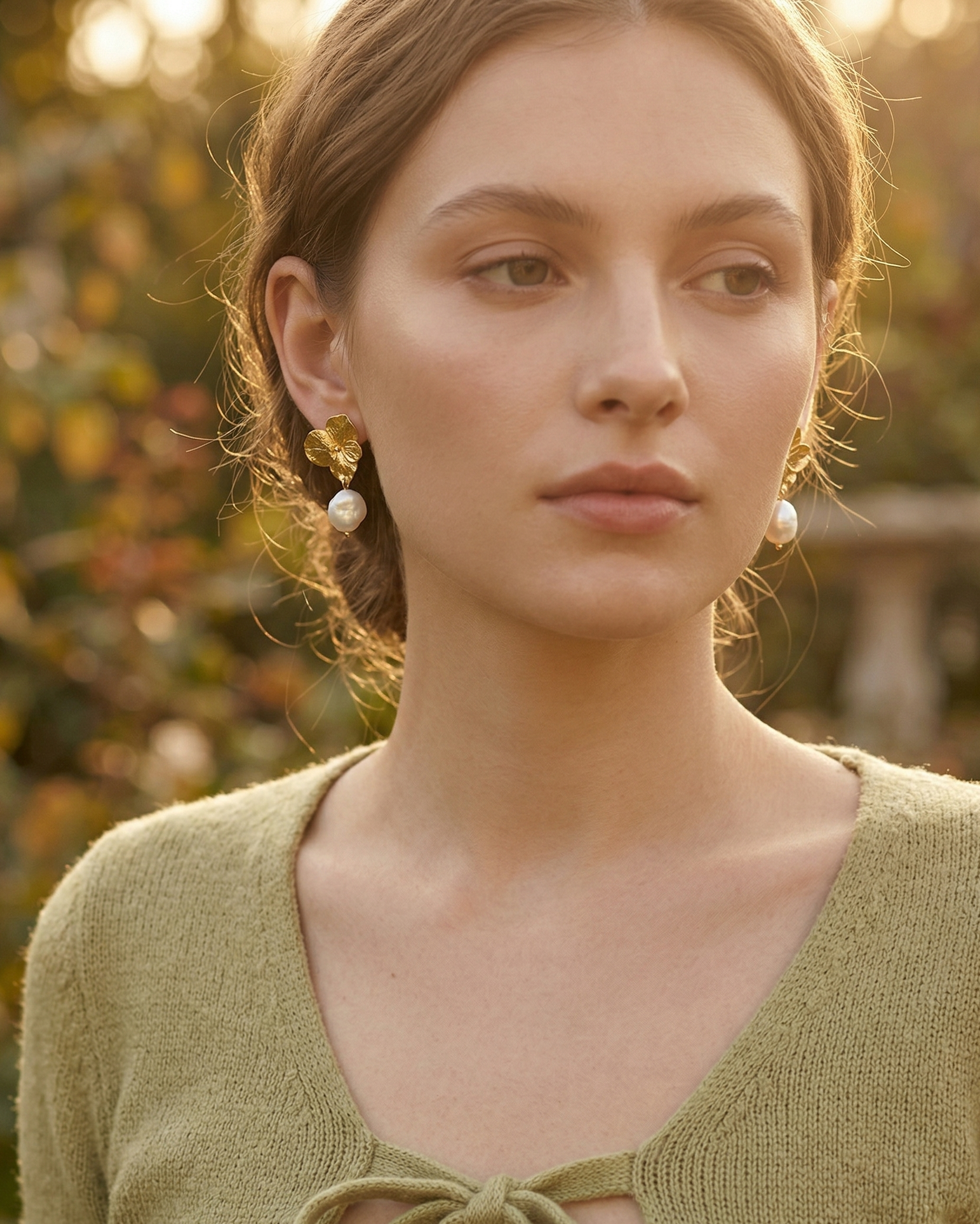 Mujer usando aretes topo Hortensia Perla de Liz de la Cruz, joyería botánica colombiana hecha a mano