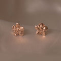 Aretes Topo Mini Flor Sauco en bronce bañado en oro de 24k, mostrando la delicadeza y la forma única de la flor natural.