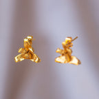 Aretes artesanales de Orquidea Maxilaria inmortalizada en bronce con baño en oro, mostrando detalles únicos de la flor