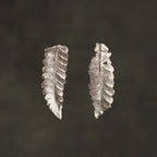 Aretes Topo Helecho Canela en plata ecológica, cada uno mostrando la elegancia única de una hoja natural de helecho de nuestro jardín