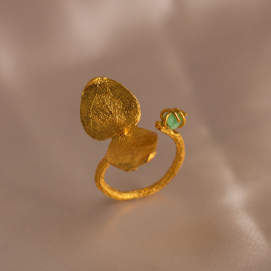 Anillo Eucalipto Ramita Esmeralda en bronce bañado en oro de 24k, destacando la forma única de la hoja y el brillante verde de la esmeralda colombiana.