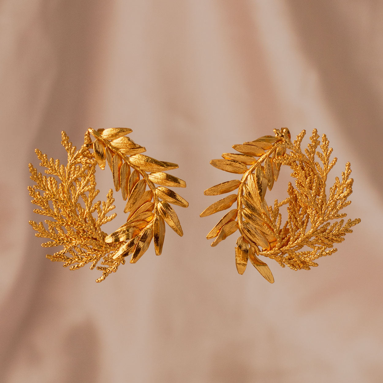 Aretes Romeron Hoja Pino Espiral en bronce bañado en oro de 24k, mostrando la forma única de hojas naturales de pino romerón y ciprés.