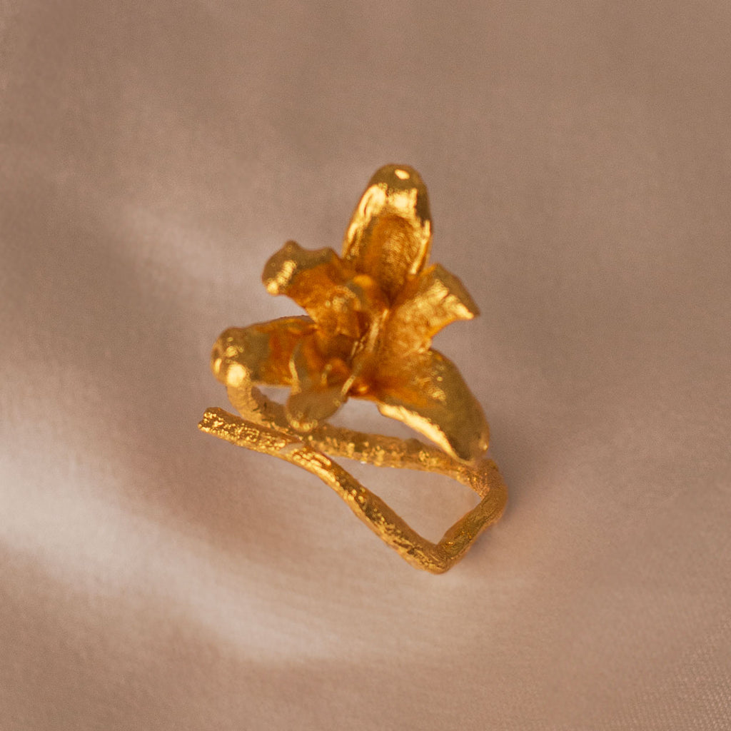 Anillo Orquídea Maxilaria en bronce bañado en oro de 24k, mostrando la forma delicada y única de una flor natural de orquídea