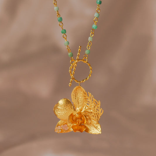Collar Aguamarina Orquídea Phalaenopsis en bronce bañado en oro de 24k con cuarzos aguamarina, reflejando la elegancia natural y la artesanía fina.