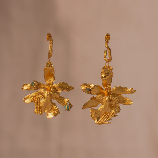 Aretes Candonga Orquidea Odontoglossum Pino Esmeralda en bronce bañado en oro de 24k, destacando la belleza única de las flores y hojas inmortalizadas con detalles de esmeralda.