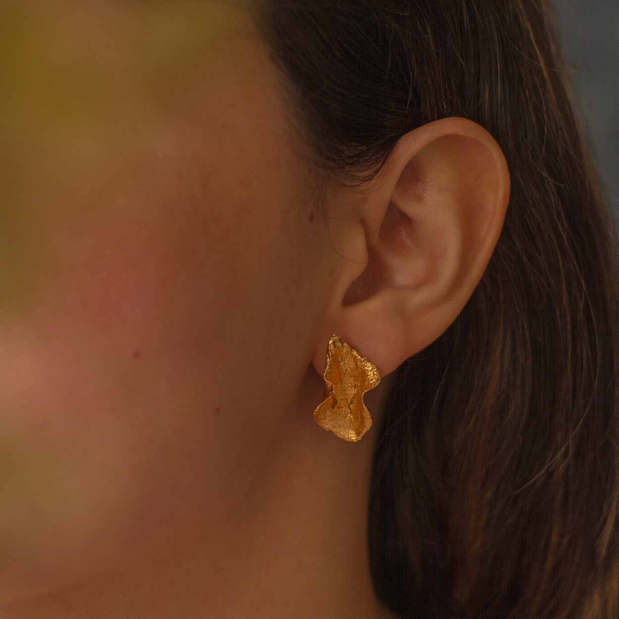Aretes Topo Conchita Ondulada en bronce bañado en oro de 24k, destacando la forma natural y única de las conchitas inmortalizadas
