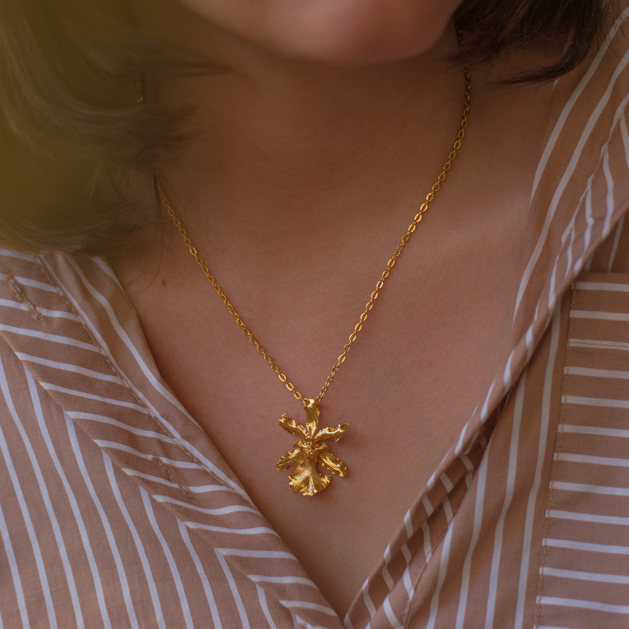 Collar Orquídea Oncidium Chocolate en bronce bañado en oro de 24k, destacando la belleza única de las flores inmortalizadas.