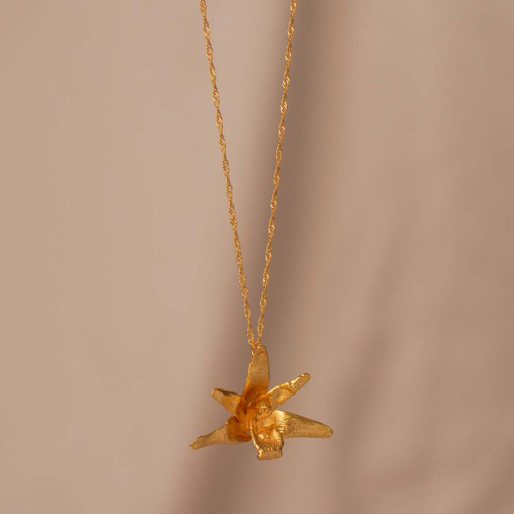 Collar Orquídea Maxilaria Grande en bronce bañado en oro de 24k, destacando la belleza única de las flores de orquídea inmortalizadas