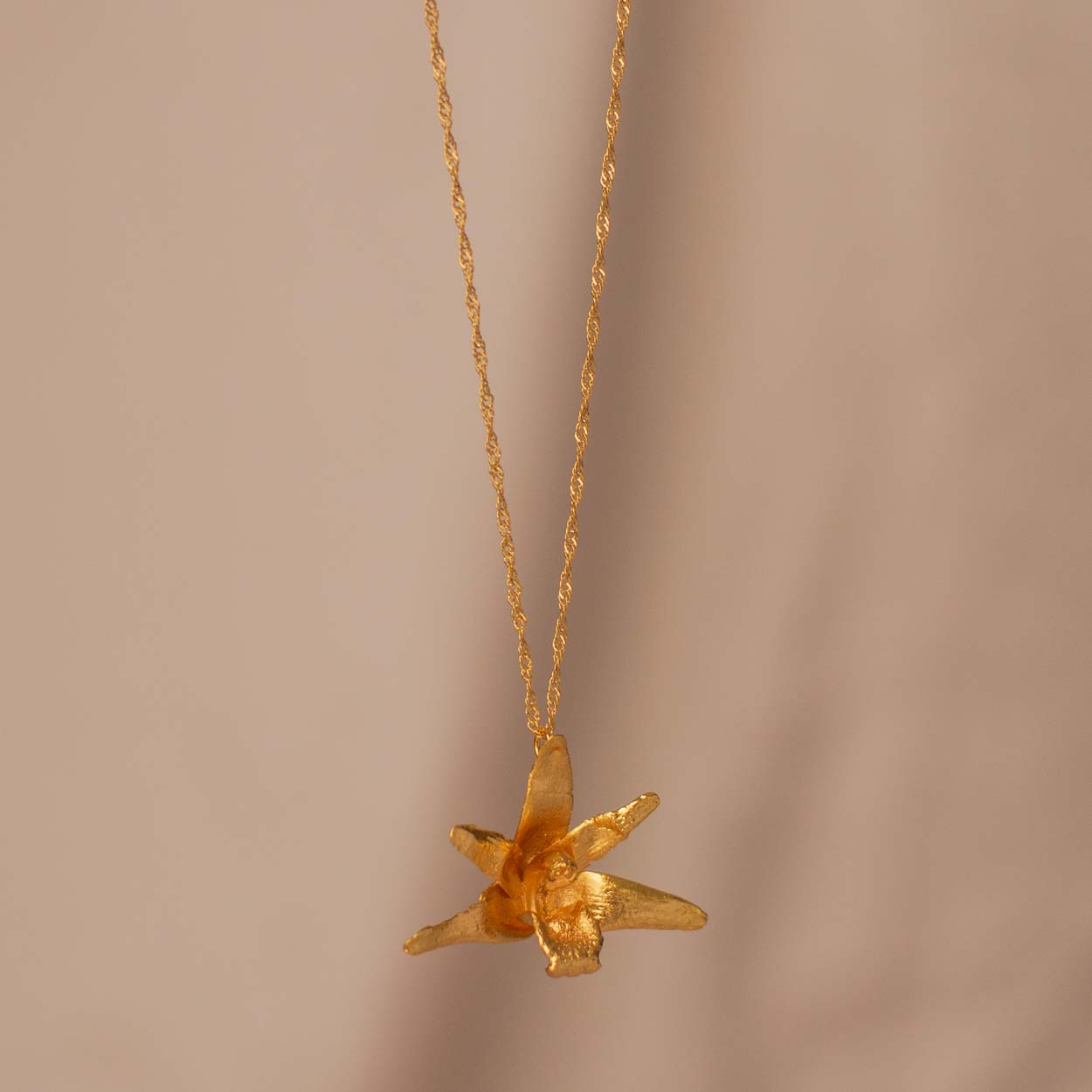 Collar Orquídea Maxilaria Grande en bronce bañado en oro de 24k, destacando la belleza única de las flores de orquídea inmortalizadas