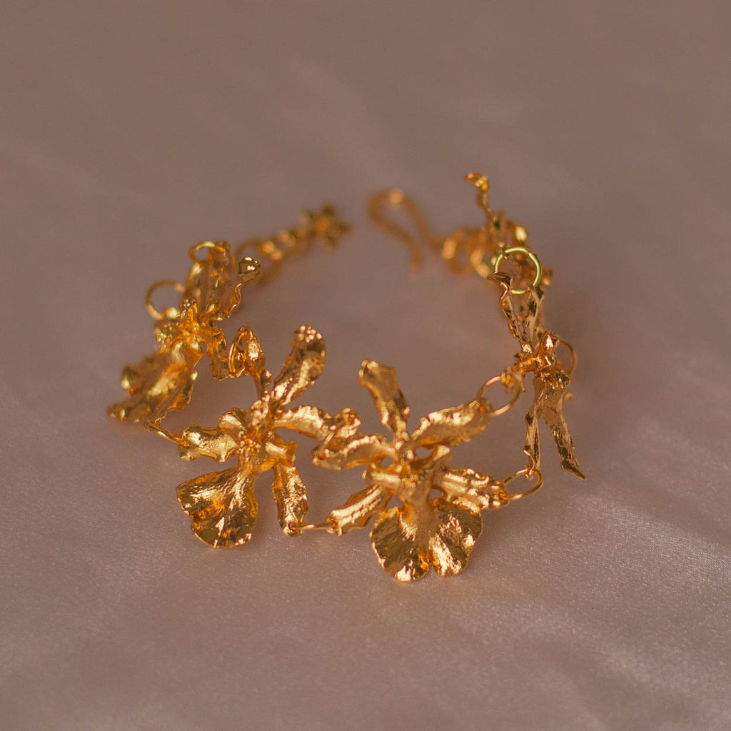 Pulsera Cinco Orquídeas Chocolate en bronce bañado en oro de 24k, destacando la belleza única de las orquídeas inmortalizadas.