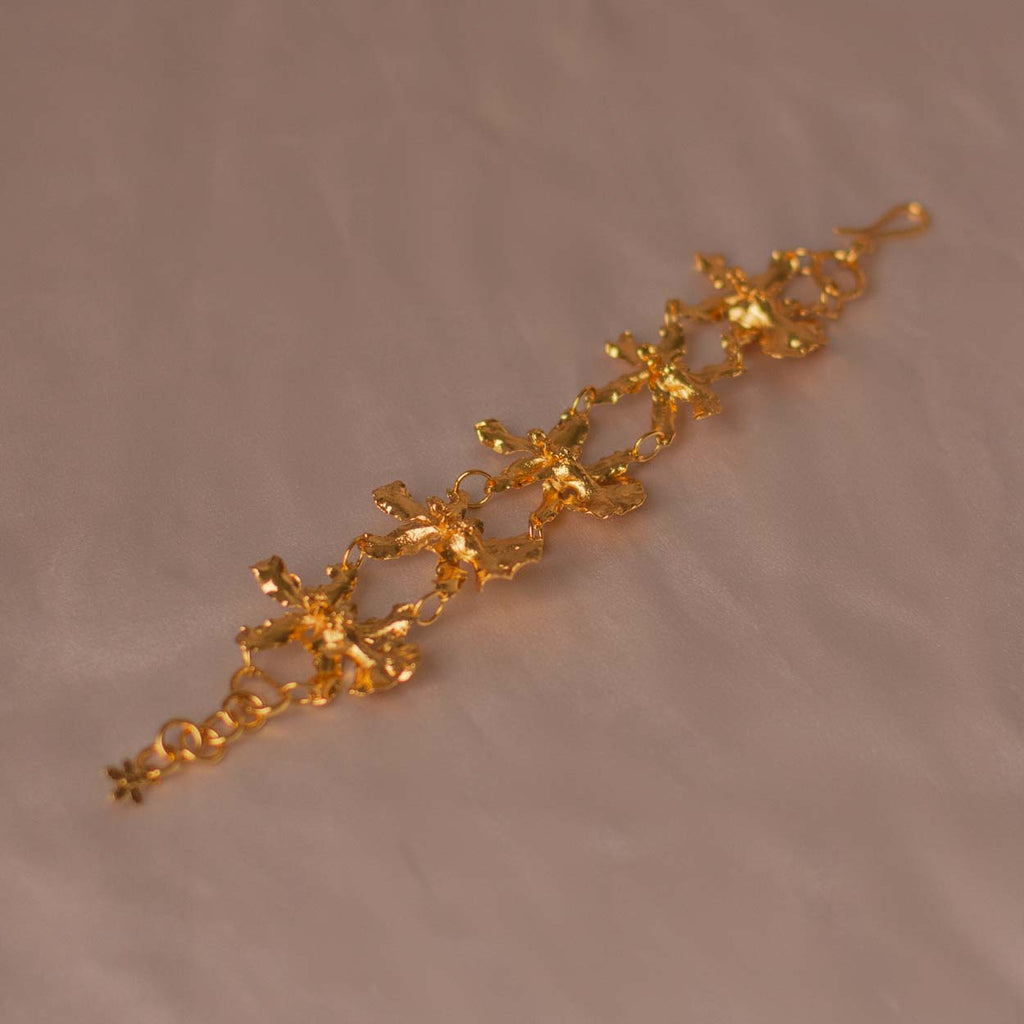 Pulsera Cinco Orquídeas Chocolate en bronce bañado en oro de 24k, destacando la belleza única de las orquídeas inmortalizadas.