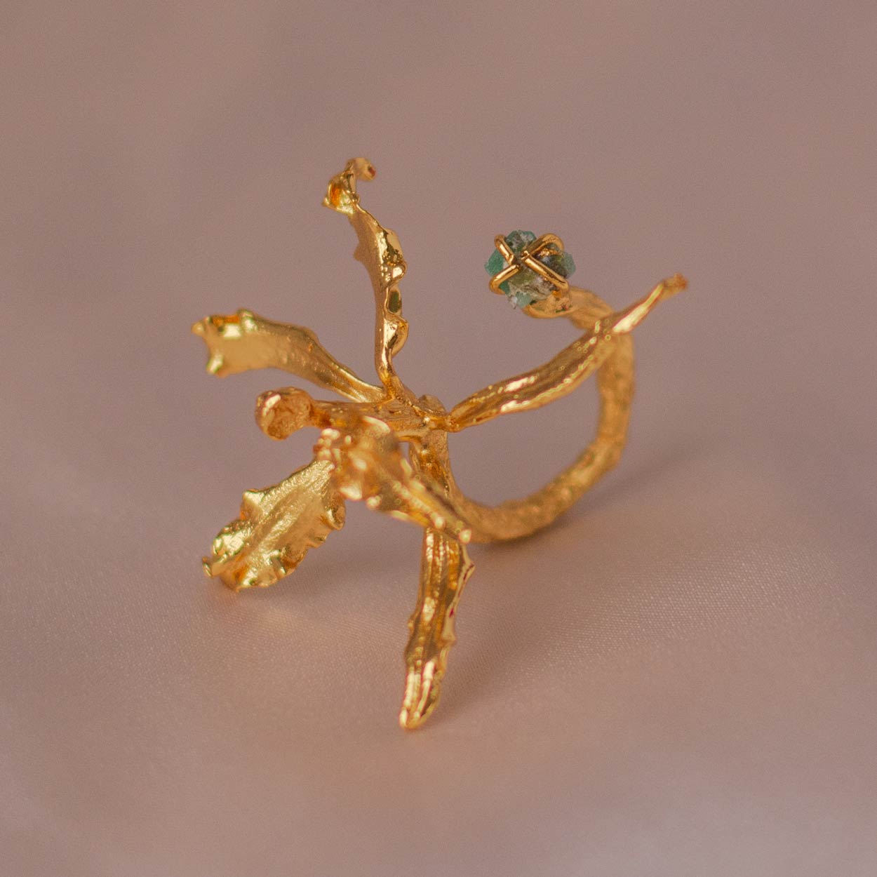 Anillo exclusivo con orquídea inmortalizada y esmeralda colombiana, en oro de 24k
