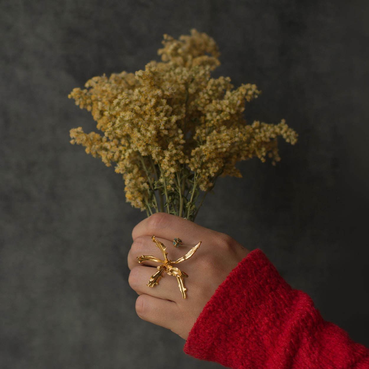 Anillo exclusivo con orquídea inmortalizada y esmeralda colombiana, en oro de 24k
