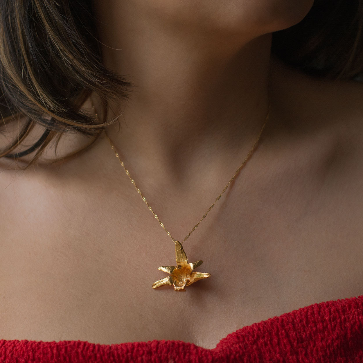 Collar Orquídea Maxilaria Grande en bronce bañado en oro de 24k, destacando la belleza única de las flores de orquídea inmortalizadas