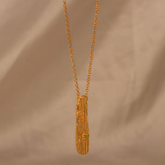 Collar artesanal con textura de corteza de palma y esmeralda colombiana