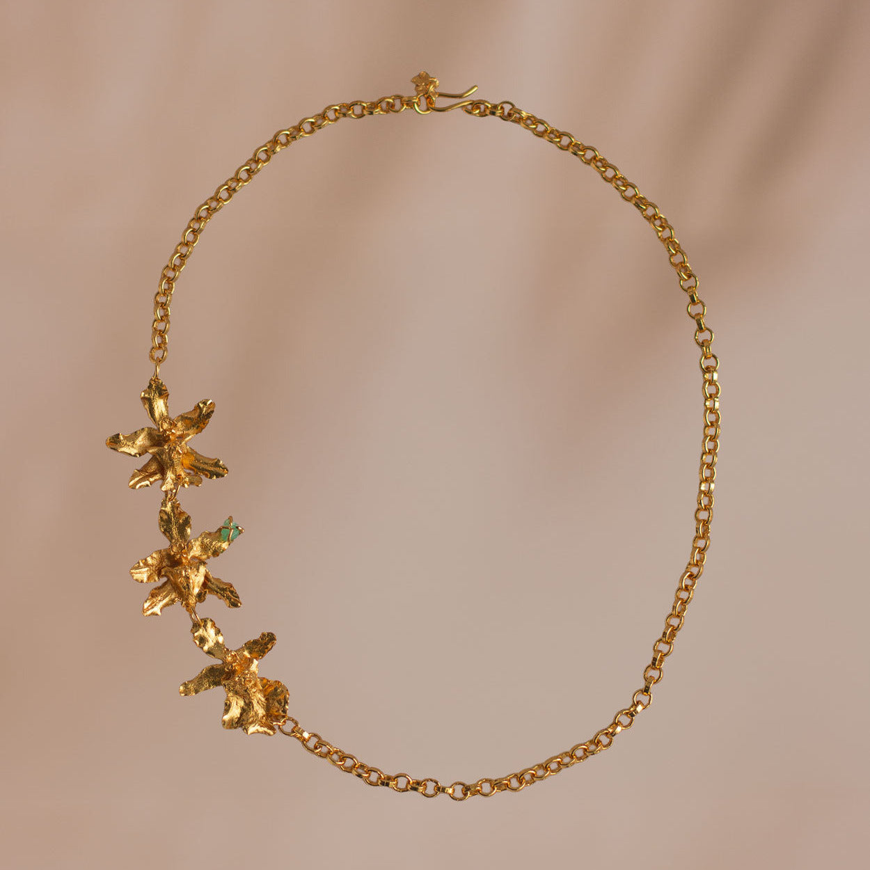 collar choker con orquídeas chocolate y esmeralda en oro
