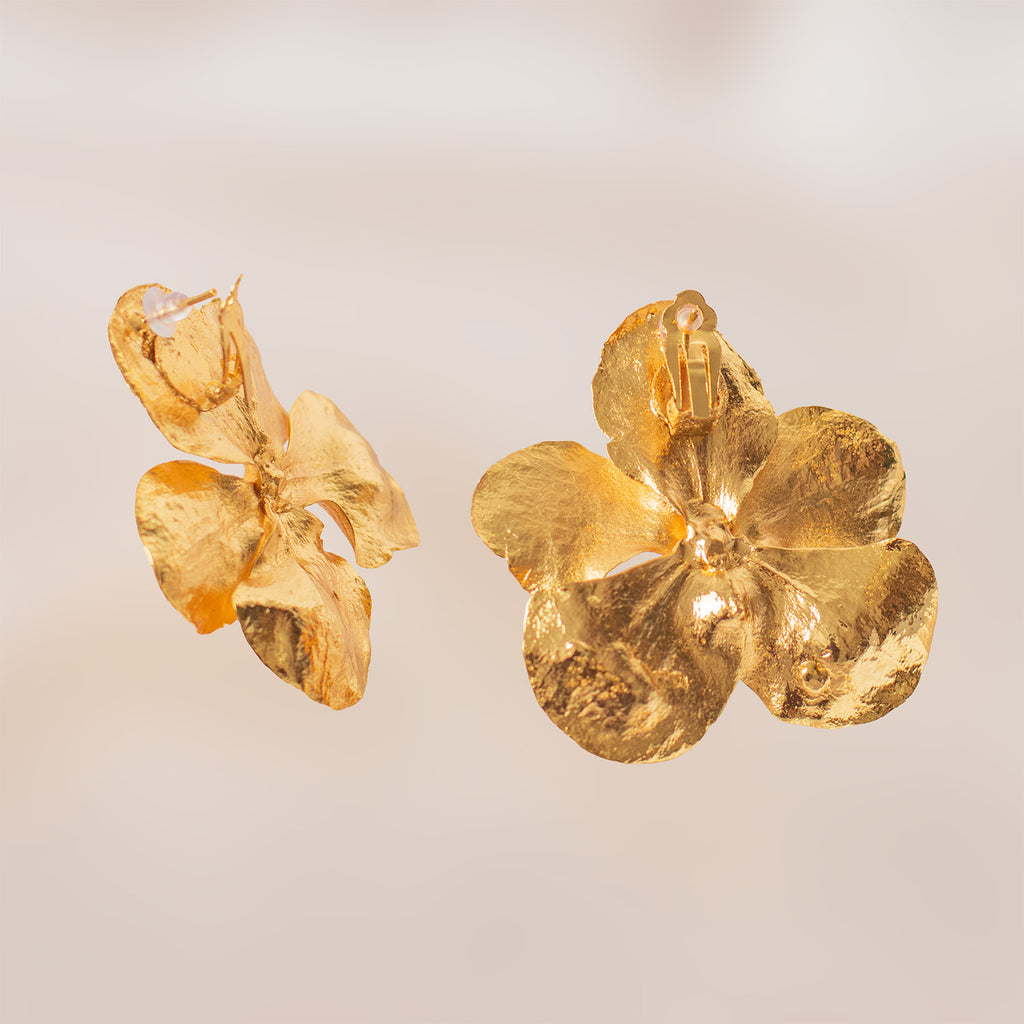 Vista lateral de aretes de orquídea Vanda dorada resaltando el cierre de alta calidad y la textura orgánica preservada de la flor.