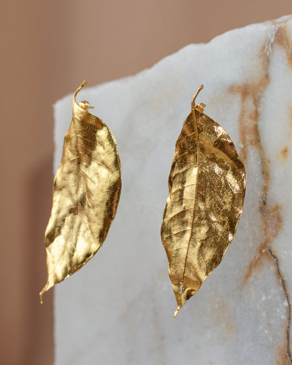 Aretes Topo Hoja Cúcuta en bronce bañado en oro de 24k, destacando la delicadeza y la forma única de las hojas naturales