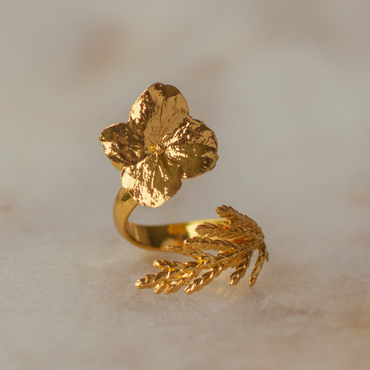Anillo Hortensia Hoja Pino en bronce bañado en oro de 24k, combinando la elegancia de las flores de hortensia con la sutileza de las hojas de pino