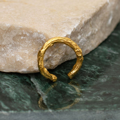 Earcuff Ramita Mediano en bronce bañado en oro de 24k, mostrando la forma natural de las ramitas de palma inmortalizadas