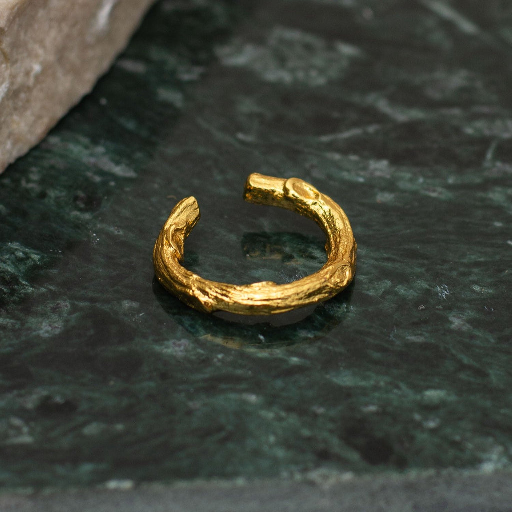 Earcuff Ramita Mediano en bronce bañado en oro de 24k, mostrando la forma natural de las ramitas de palma inmortalizadas