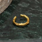 Earcuff Ramita Mediano en bronce bañado en oro de 24k, mostrando la forma natural de las ramitas de palma inmortalizadas