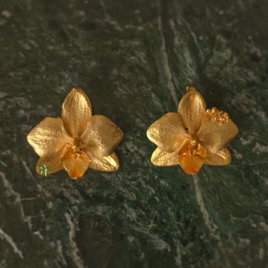 Aretes Orquidea Phalaenopsis natural inmortalizado en bronce con enchape de oro con detalle de esmeralda colombiana y flores de sauco