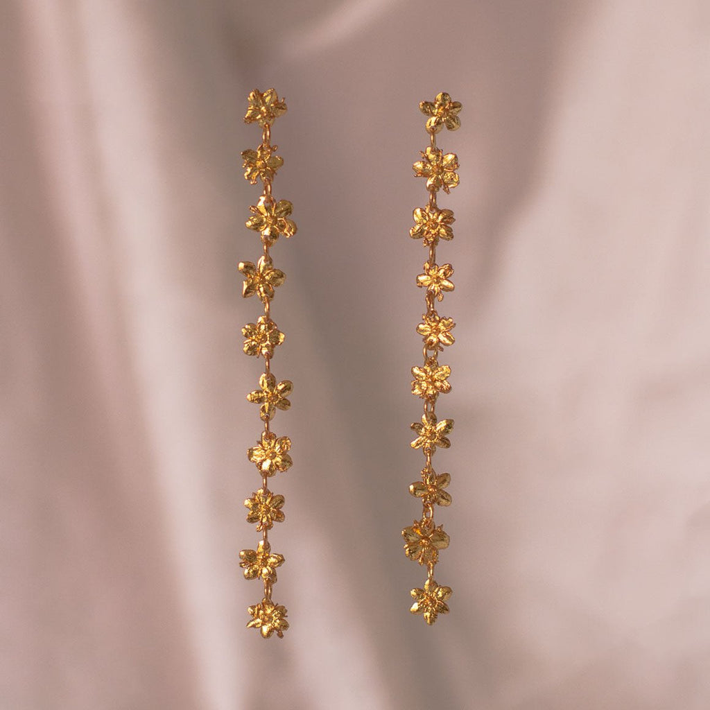 Aretes Large Sauco en bronce bañado en oro de 24k, con diez flores de sauco inmortalizadas en un diseño largo y articulado