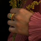 Anillo Ramita con Esmeralda en bronce bañado en oro de 24k, destacando la textura natural de la ramita y el brillante verde de la esmeralda
