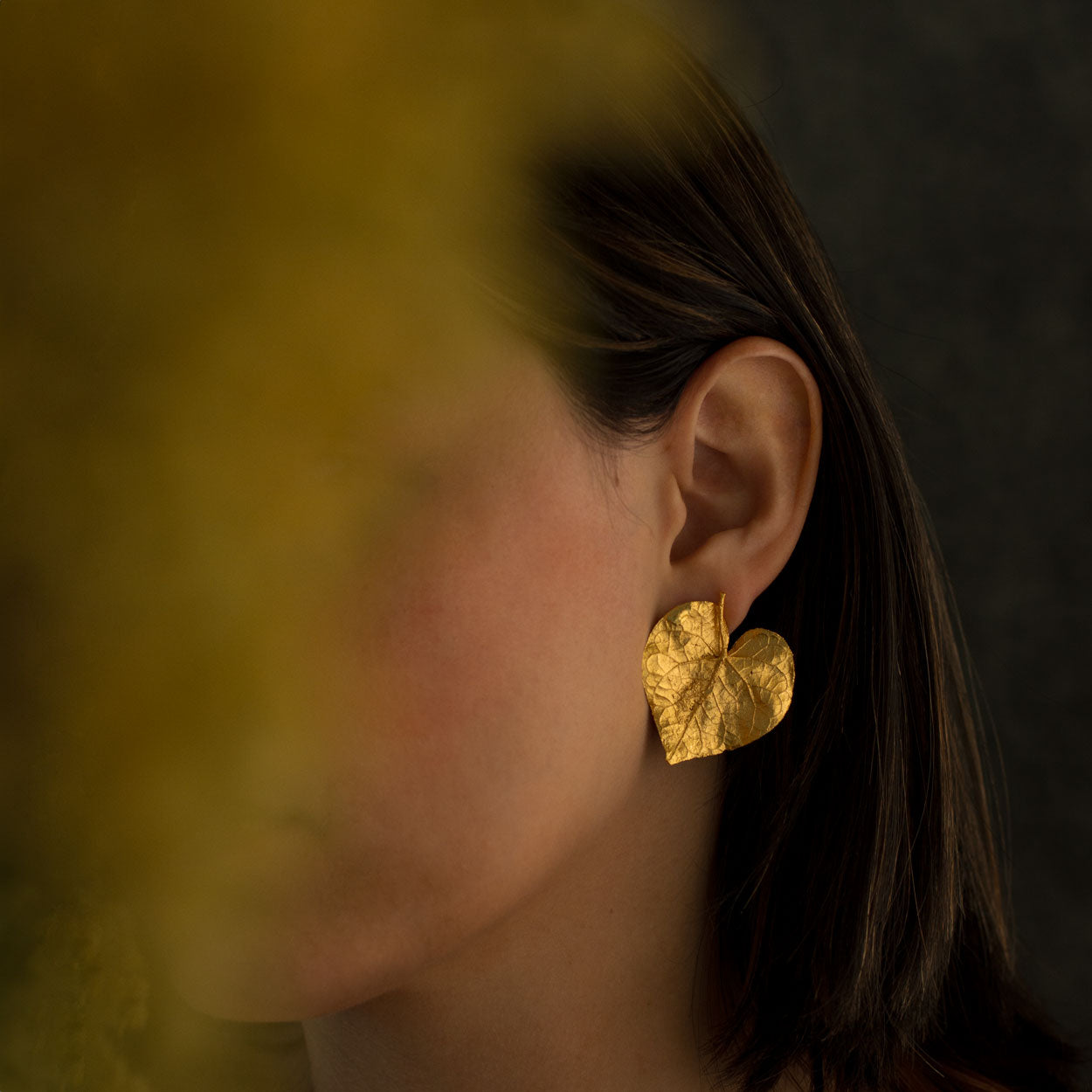 Aretes Topo Hoja Corazón en bronce bañado en oro de 24k, mostrando la delicadeza y la forma única de las hojas naturales en forma de corazón