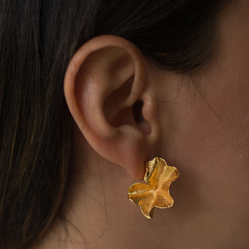 Detalle de aretes botánicos de hoja de hiedra con baño en oro de 24k
