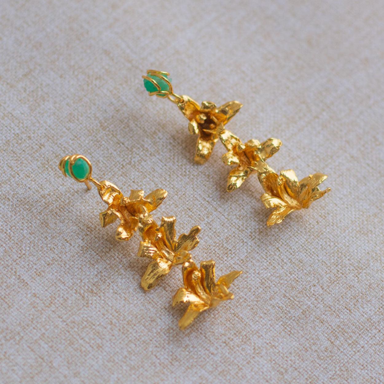 Pendientes artesanales con flores naturales de orquídea Maxilaria en bronce dorado con esmeraldas
