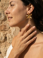 Aretes topo orquídea Encyclia oncidioides oro 24k, pétalos estrellados naturales en metal, hechos a mano en Bogotá


