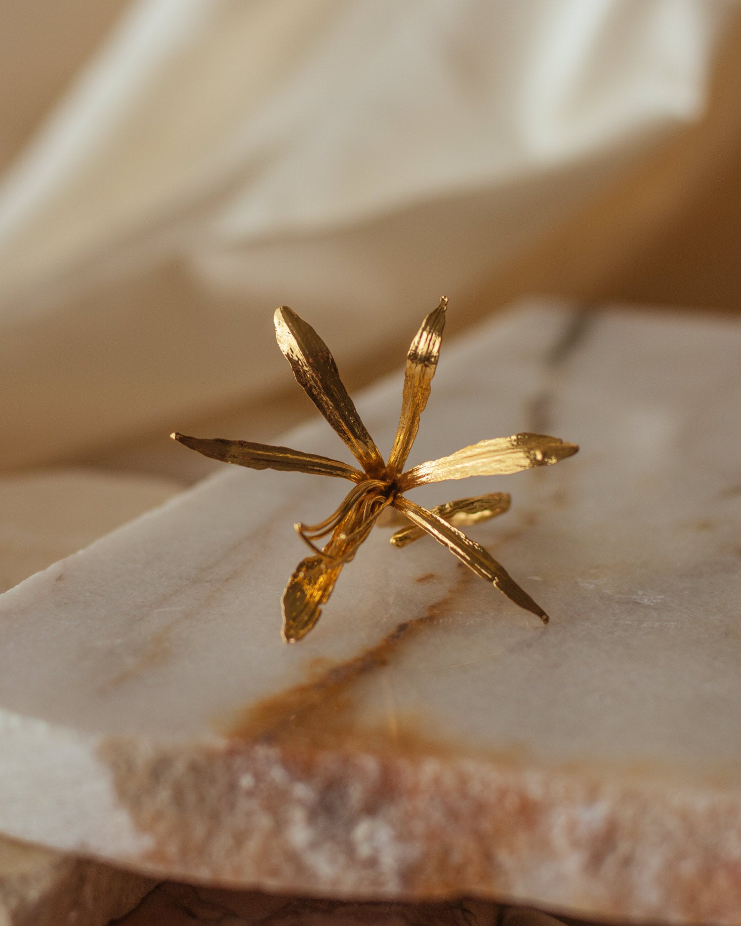 Anillo Lirio Agapanto en bronce bañado en oro de 24k, destacando la delicadeza y la forma única de la flor natural recolectada en Bogotá