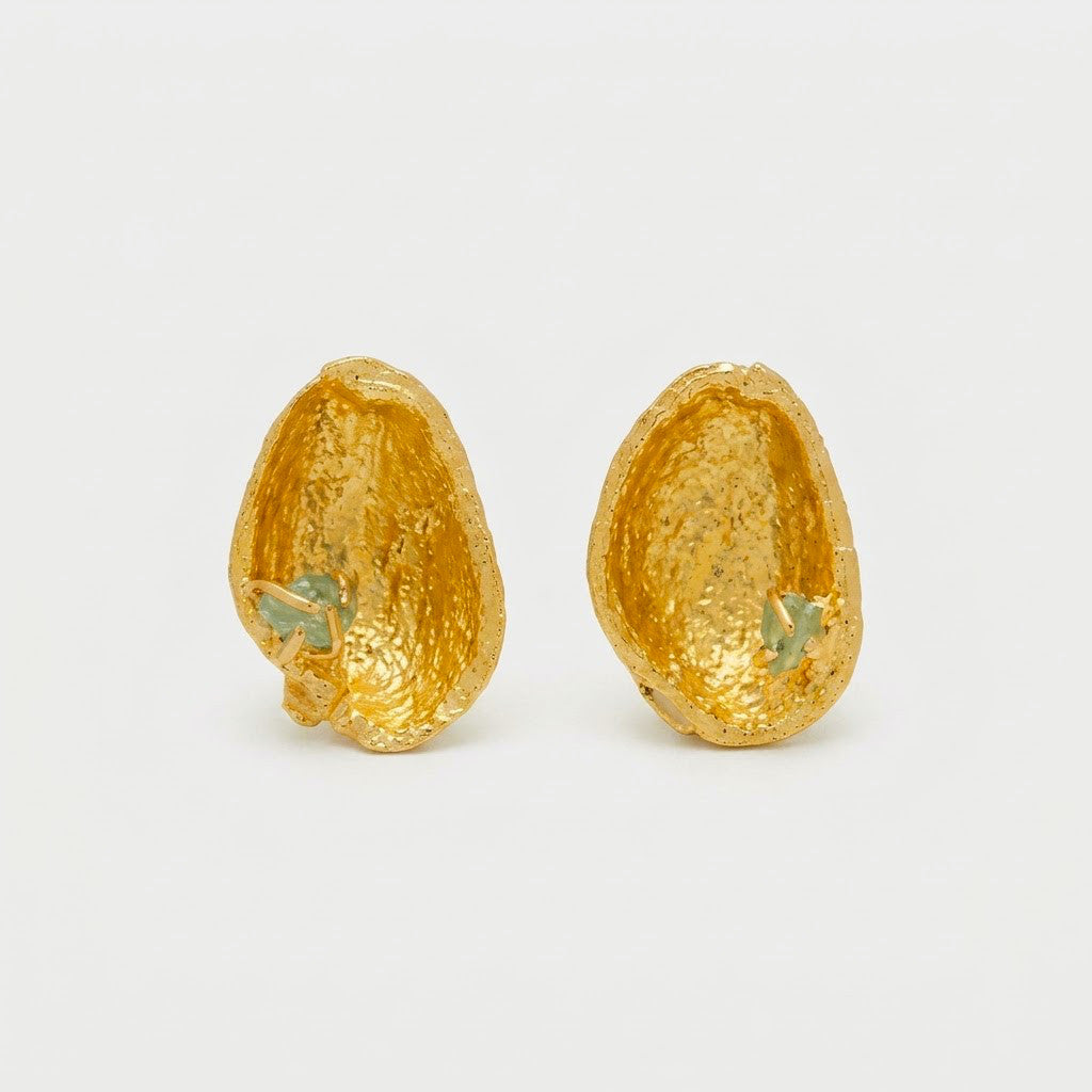 Joyería botánica Colombia: aretes topo cáscara pistacho oro 24k con esmeralda colombiana en bruto, fundición orgánica directa, naturaleza inmortalizada