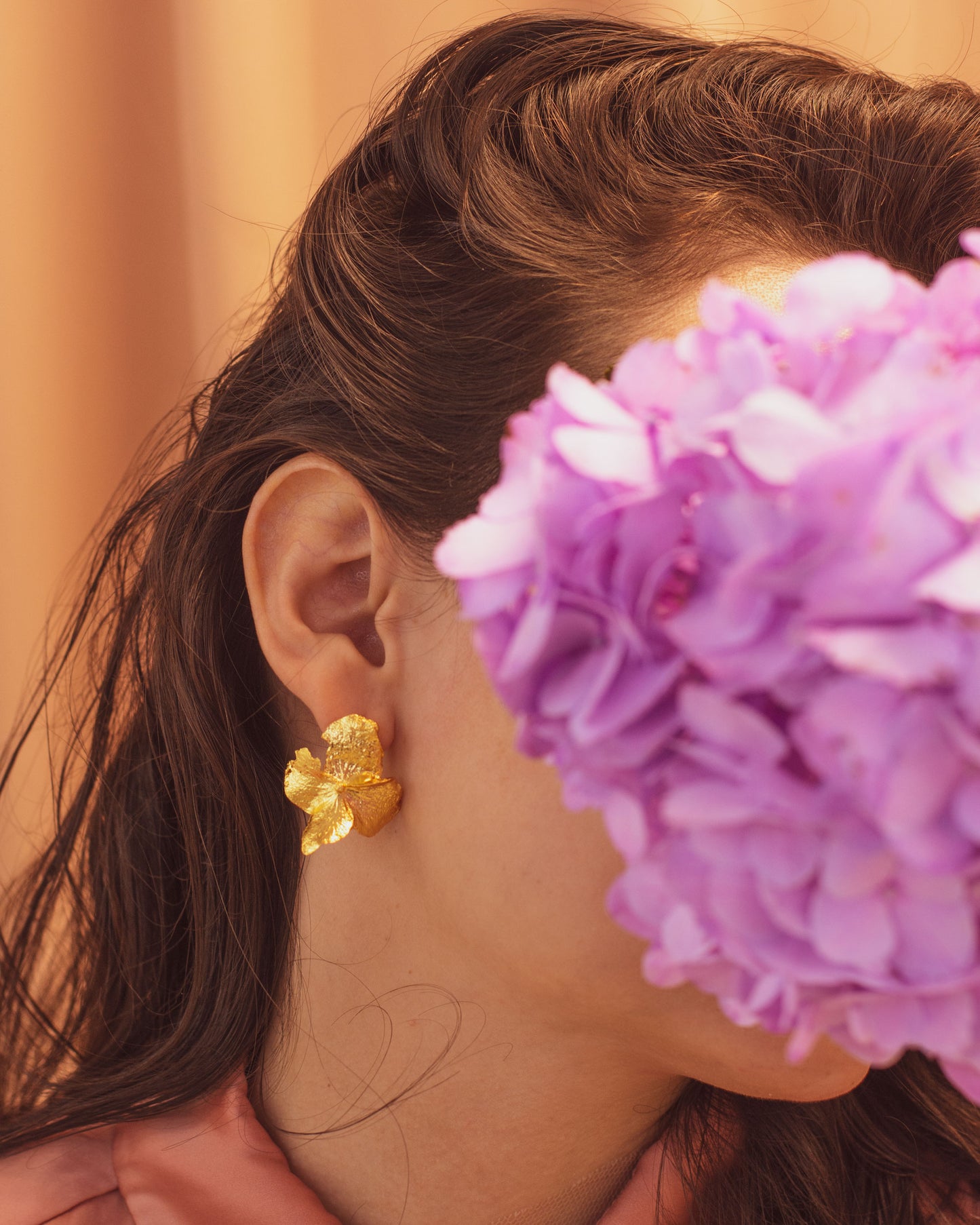 Aretes Topo Flor Hortensia en bronce bañado en oro de 24k, destacando la belleza única de las flores naturales de hortensia de nuestro jardín
