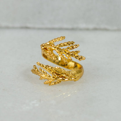 Anillo Hojitas Mini Pino en bronce bañado en oro de 24k, mostrando la textura y forma delicada de las hojitas naturales.