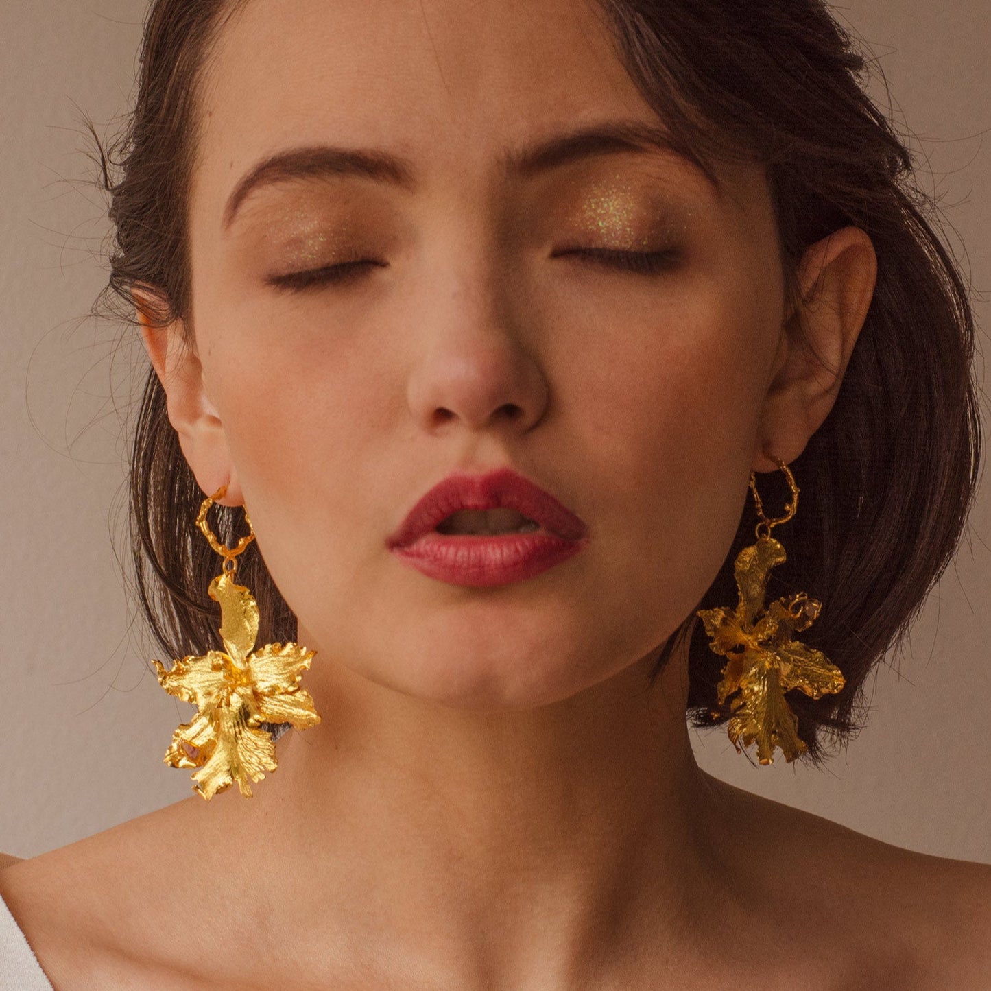 Modelo con Aretes Aro Orquidea Odontoglossum natural inmortalizado en bronce con cuarzos naturales